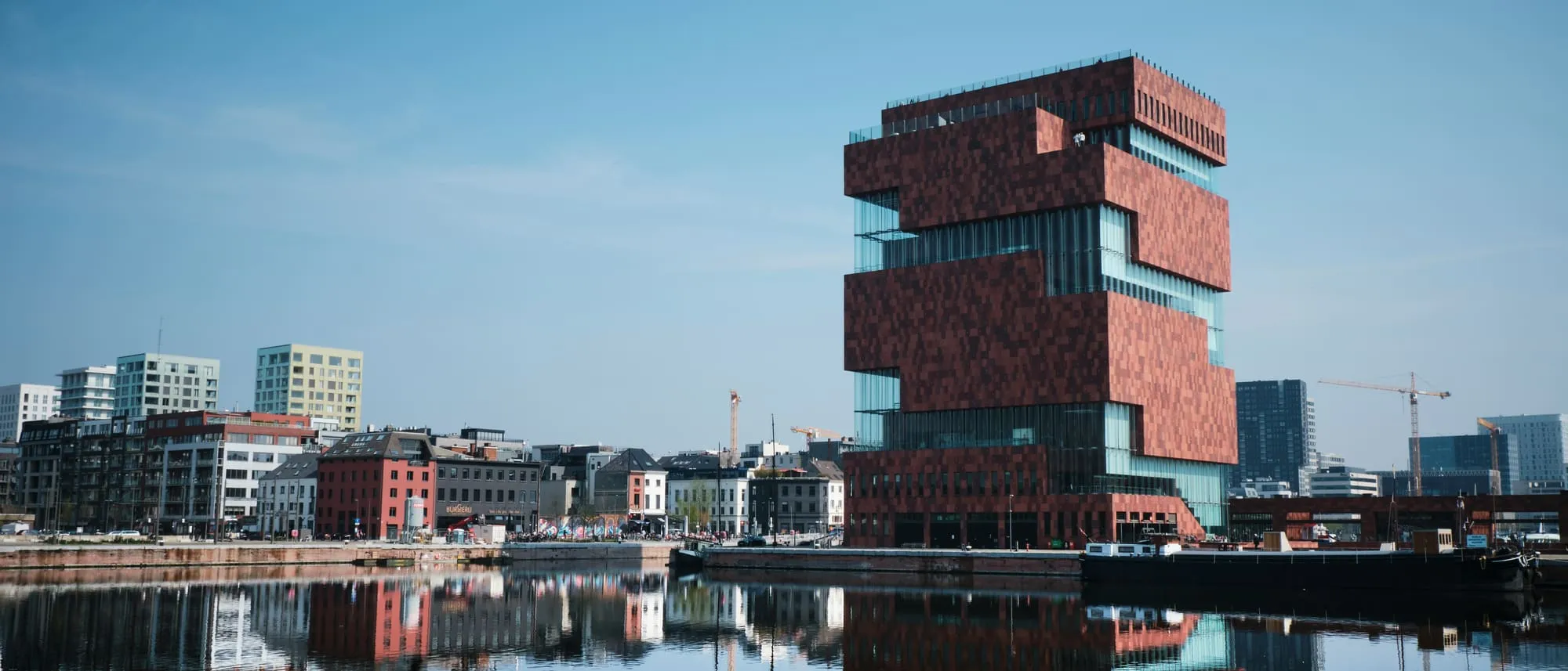 Het MAS aan het Eilandje in Antwerpen, weerspiegeld in het water van de dokken