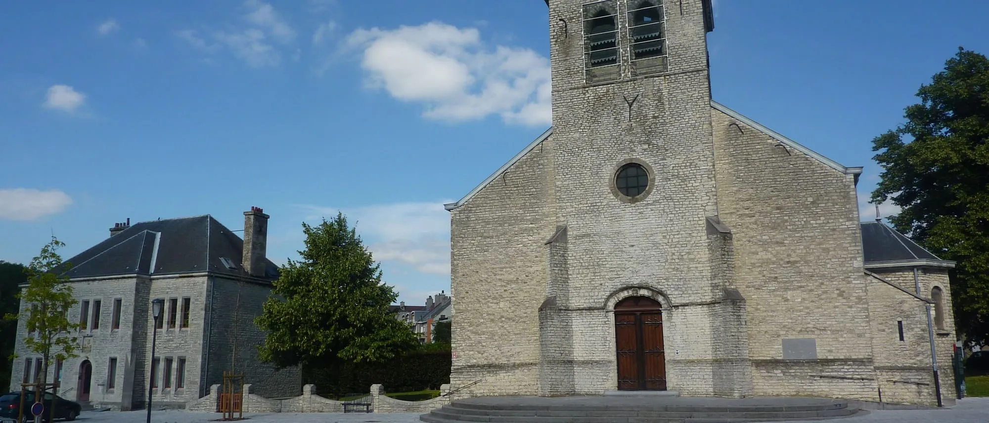 L'église Saint-Vincent et la place du vieux village d'Evere sous un ciel bleu