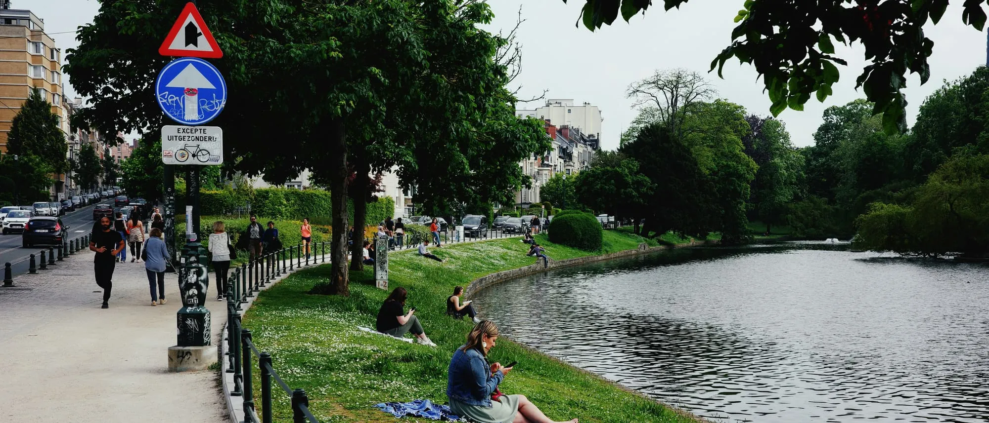 Promeneurs sur les berges verdoyantes des étangs d'Ixelles, près de la place Flagey