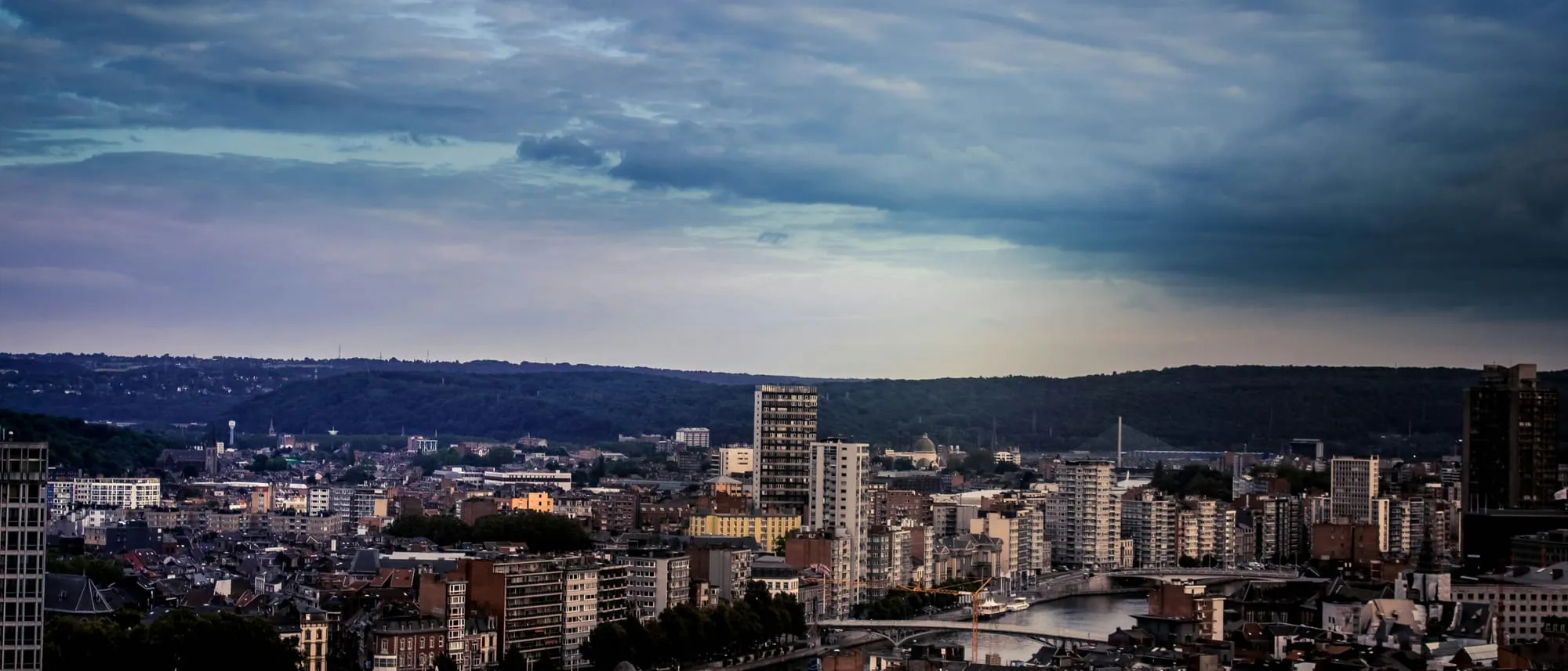 Vue sur les toits de Liège et la Meuse depuis les hauteurs, sous un ciel nuageux