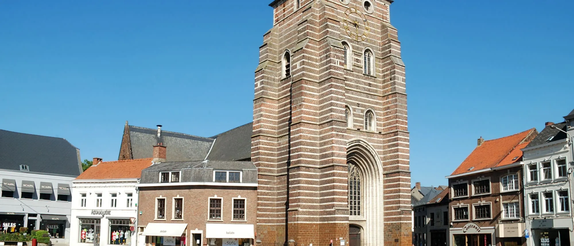 Tour de l'église Saint-Jean-Baptiste de Wavre entourée de maisons du centre-ville